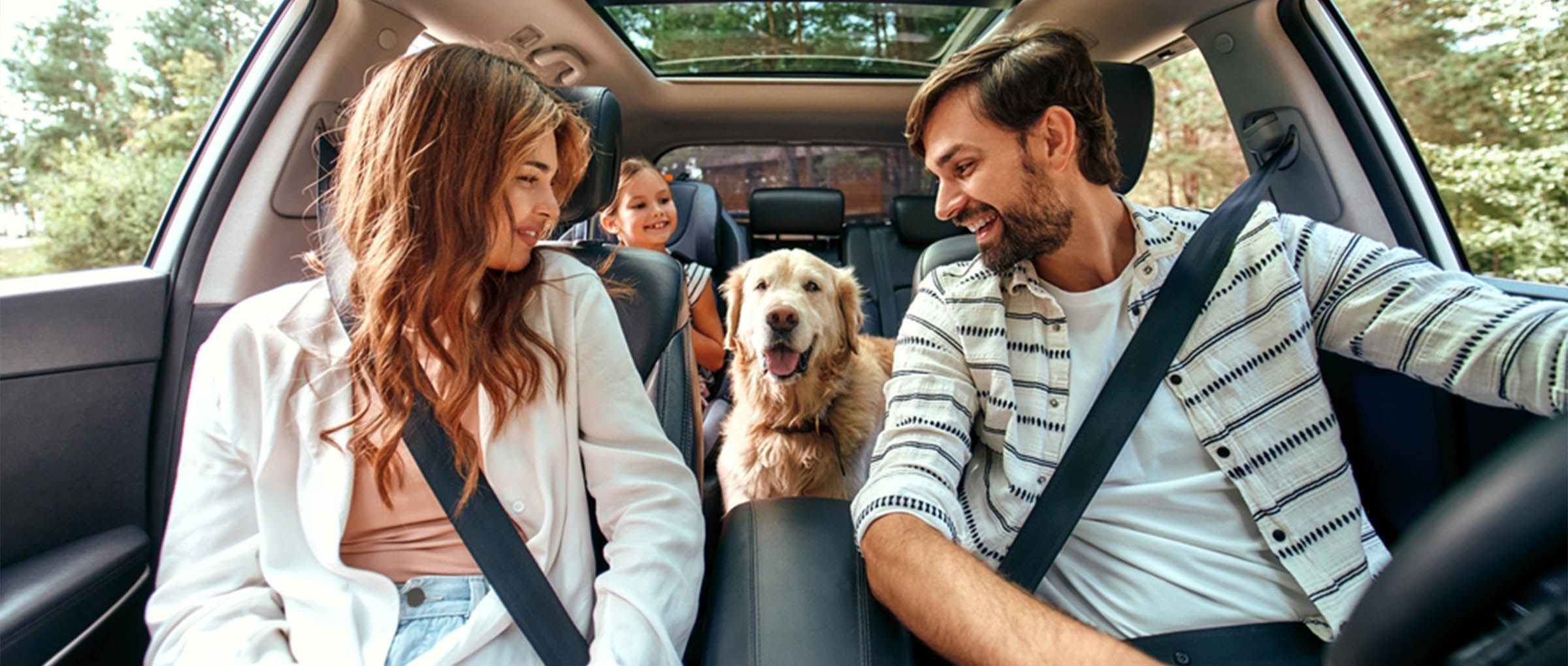 Family driving in a car with seatbelts fastened - https://kalivasinsurance.com/